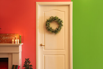 White door with Christmas mistletoe wreath in living room