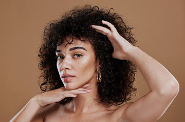 Face, skincare and hair with a model black woman in studio on a brown background for natural...