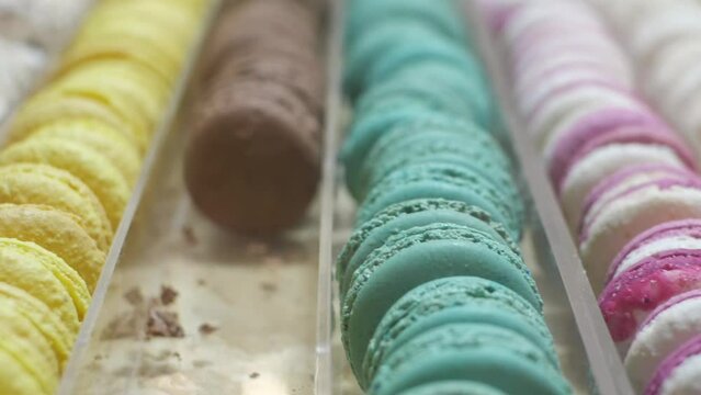 Closeup Of Colorful French Macarons Sorted In Rows. Bakeshop Display. sideways
