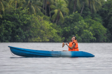 girl paddles on a lake in a kayak