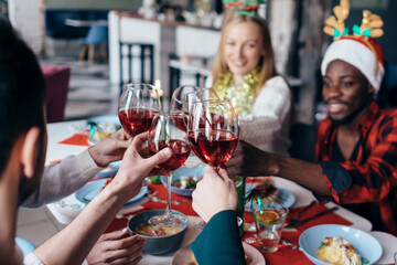 Group of people at a festive table clink glasses