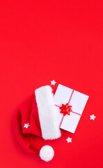 gift box in a hat santa claus on a red background top view with place for text