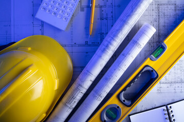 Contractor theme. Plans,  notebook and tool kit of the contractor: yellow hardhat, libella, saw and...