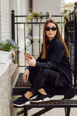 Cheerful beautiful brunette woman in good mood use phone outside