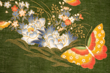 Butterfly and flowers pattern part of the old japanese fabric on green background.