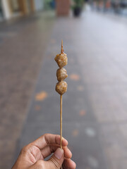 Small grilled meatballs are pierced and hand-held. Local Street Food in Indonesia