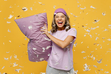 Calm young fun woman she wears purple pyjamas jam sleep eye mask rest relax at home play pillow...