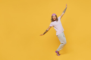 Fototapeta na wymiar Full body young fun woman she wears purple pyjamas jam sleep eye mask rest relax at home dance with outstretched hands stand on toes leaning back isolated on plain yellow background Night nap concept