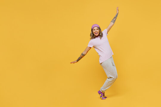 Full Body Young Fun Woman She Wears Purple Pyjamas Jam Sleep Eye Mask Rest Relax At Home Dance With Outstretched Hands Stand On Toes Leaning Back Isolated On Plain Yellow Background Night Nap Concept