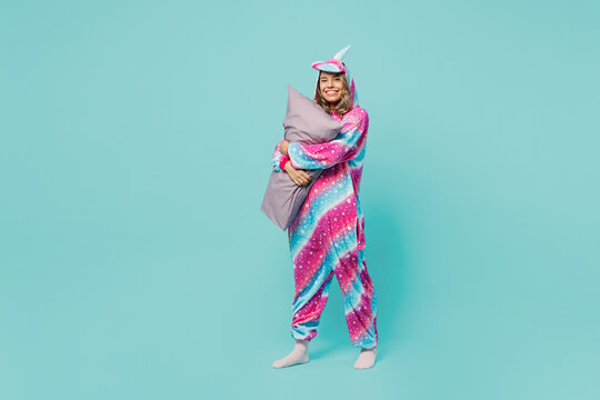 Full body young smiling happy fun woman wear domestic costume with hoody and animals ears hold in hand pillow look camera isolated on plain pastel light blue cyan background. People lifestyle concept.