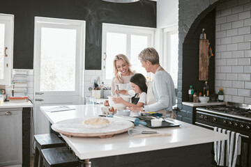 Grandmother, mother and child baking in the kitchen together while bonding in the family home. Senior woman, mom and girl kid cooking food for dinner or lunch for party, celebration or event at house