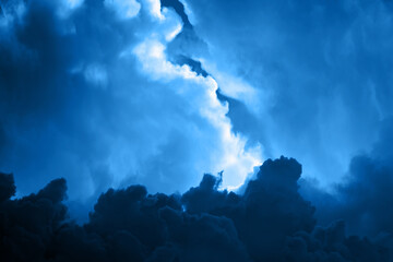 Dark blue toned sky with gloomy dramatic clouds. Backdrop background for mockup