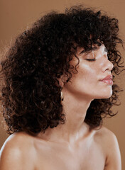 Face, beauty and hair with a model black woman in studio on a brown background for wellness or...