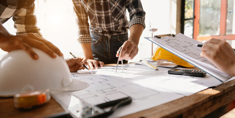 Engineer people meeting working in office for discussing, engineering .Hands of Engineer working on blueprint Construction concept..