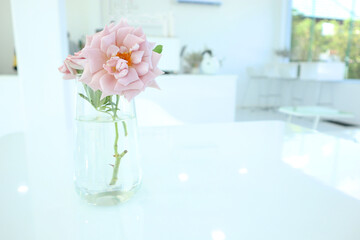 Bouquet of roses in glass standing on white table