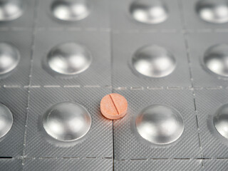 Pink pill on the background of packed pills. medicine in tablets.