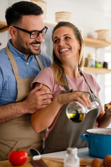 Attractive couple is cooking together organic healthy food in kitchen.
