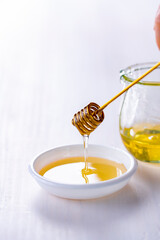 Honey with honey dipper on white table.
Sweet honey image.