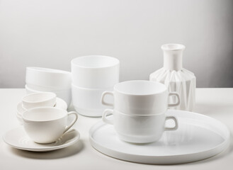 Different ceramic white dishes on a white table.