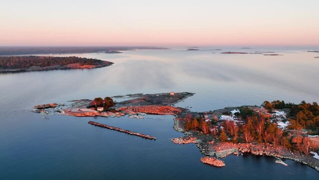 Aerial view overlooking the rocky islands with snow, spring, sunrise in the archipelago of Finland