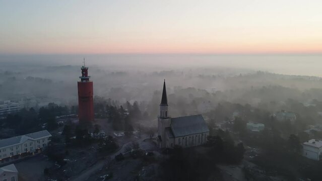 Aerial view around the church and water tower, foggy, spring morning in Hanko, Finland - orbit, drone shot