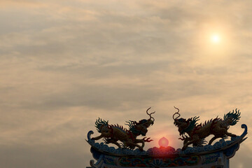 Photo of Kirin in a Chinese fable on the roof of a Chinese temple in Thailand in a cloudy sky...
