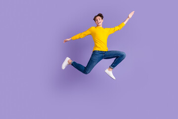 Fototapeta na wymiar Full size photo of crazy carefree guy jump high hands aside isolated bright studio shot background