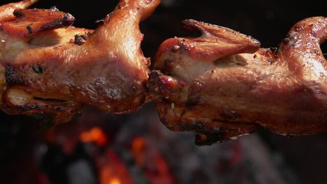 Close-up panorama of delicious quails on the skewer above the open fire