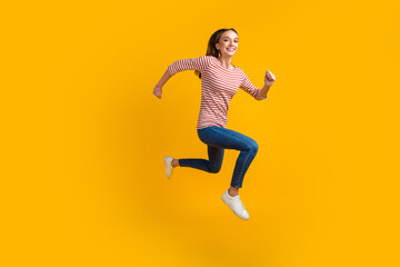 Fototapeta na wymiar Photo of smiling cheerful young brunette woman 20s years old jumping running isolated on bright color background studio