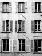fenêtres d'une facade d'un vieil immeuble en France, photo en noir et blanc