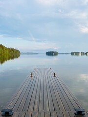 Fototapeta premium Wood dock on the autumn lake, peaceful lake surface, reflections