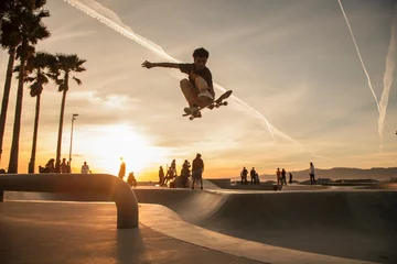 Tuinposter Teenage boy skating at skatepark during sunset © FOLIO