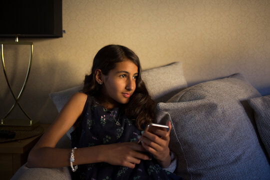 Girl with smartphone sitting on sofa