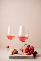 Two glasses of rose wine and red grapes.