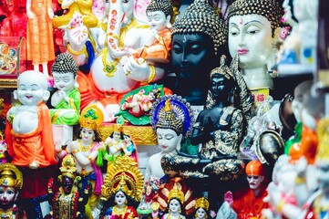 Nahaufnahme von hinduistischen und buddhistischen religiösen Statuen zum Verkauf auf einem lokalen Markt