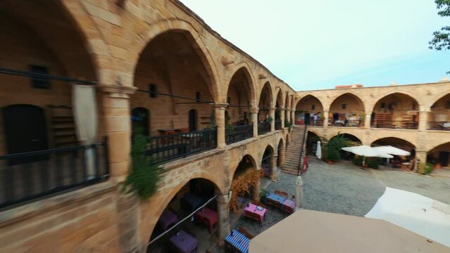 Caravanserai Buyuk Han (the Great Inn) is the largest caravanserai on the island of Cyprus. Nicosia.
Ancient Ottoman architecture. Antique arch building. Aerial view, FPV drone shot. 4K