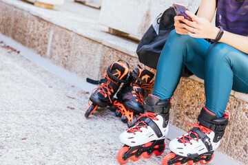 unrecognisable young girl getting ready with her mobile phone and her bag to go out on inline...
