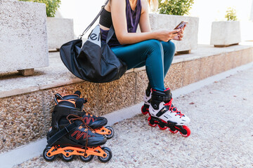 unrecognisable young girl getting ready with her mobile phone and her bag to go out on inline...