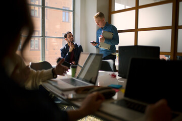 Young men talking in office