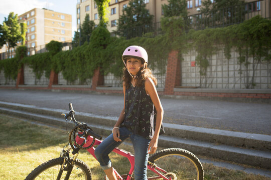 Girl sitting on bicycle in park