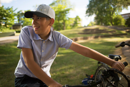 Smiling boy with bicycle in park