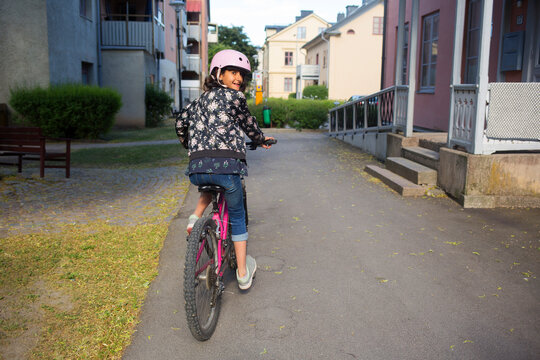 Girl riding bicycle on footpath