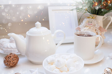  Winter, Christmas, New Year decoration composition, concept, background. White Mug, cup of hot tea, coffee, meringue, knitted plaid. Christmas lights. Christmas mood morning. Xmas greeting card.