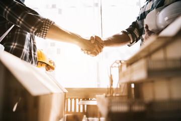 construction worker and contractor. Client shaking hands with team builder in renovation site in the morning.
