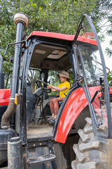 Boy driving a tractor. Boy sitting behind the wheel of a tractor. 