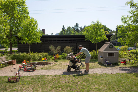 Man with daughter in stroller in backyard