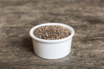 Chia seeds in bowl on colored background. Healthy Salvia hispanica in small bowl. Healthy superfood