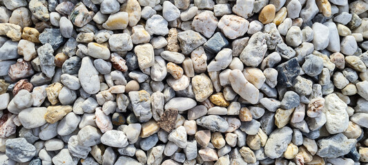 Natural gravel texture. Multi colored pebbles. Beautiful background. Vacation, holiday, beach mood.