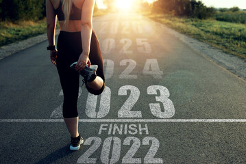 Woman stands at the finish line of 2022 and gives a new start to 2023. New goals, plans, actions and achievements in New Year.