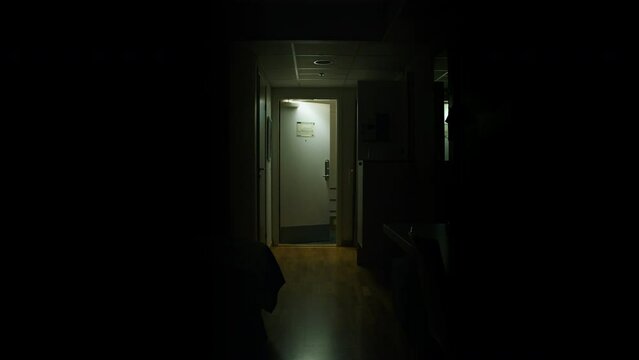 Young Man leaving dark hotel room, not looking back while door shuts, slow motion